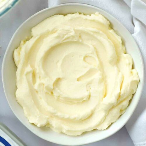 A bowl on a table with buttercream icing.