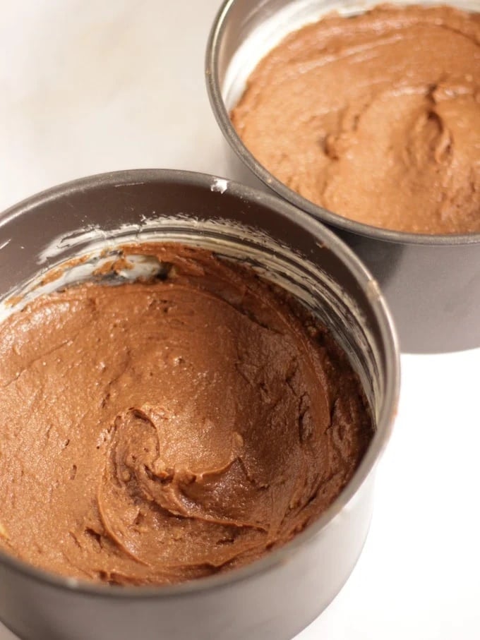 Two cake tins filled with chocolate cake batter for step 3 in the recipe for Chocolate Orange Cake.