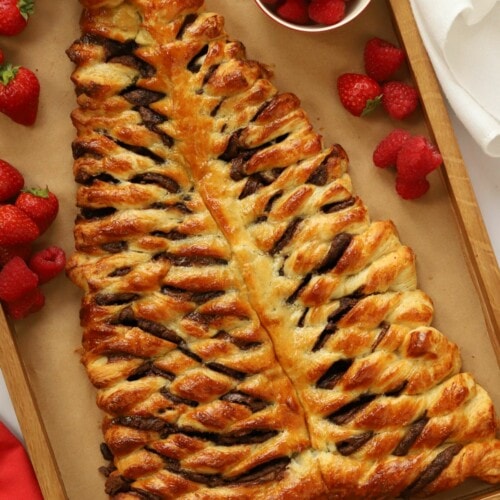 A board filled with a giant chocolate croissant in the shape of a Christmas tree.
