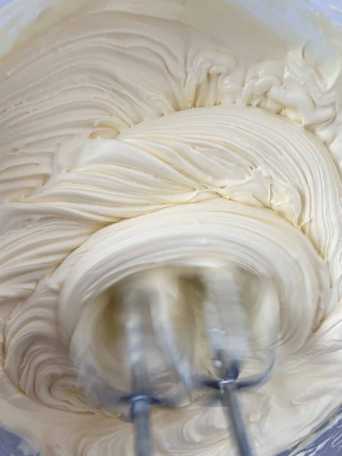 Cream being whipped with an electric whisk.