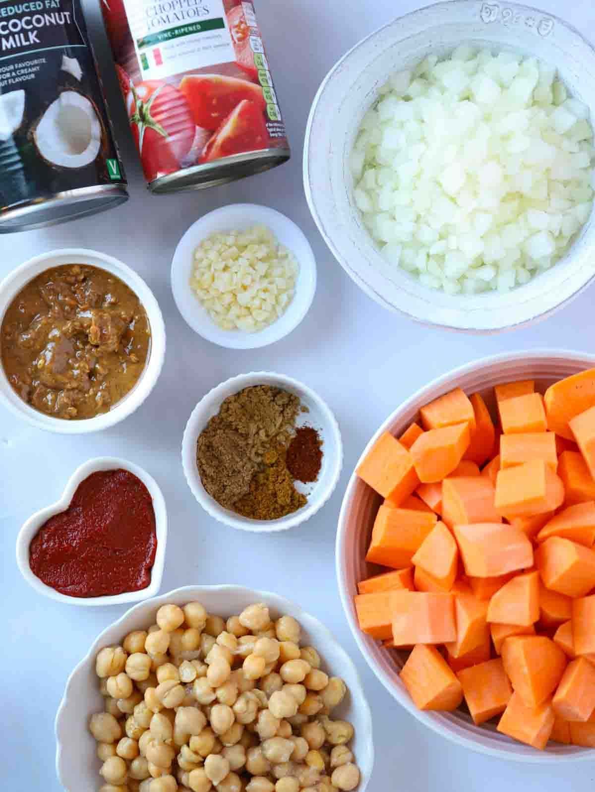The raw ingredients for a slow cooker sweet potato vegan stew laid out on a counter top.