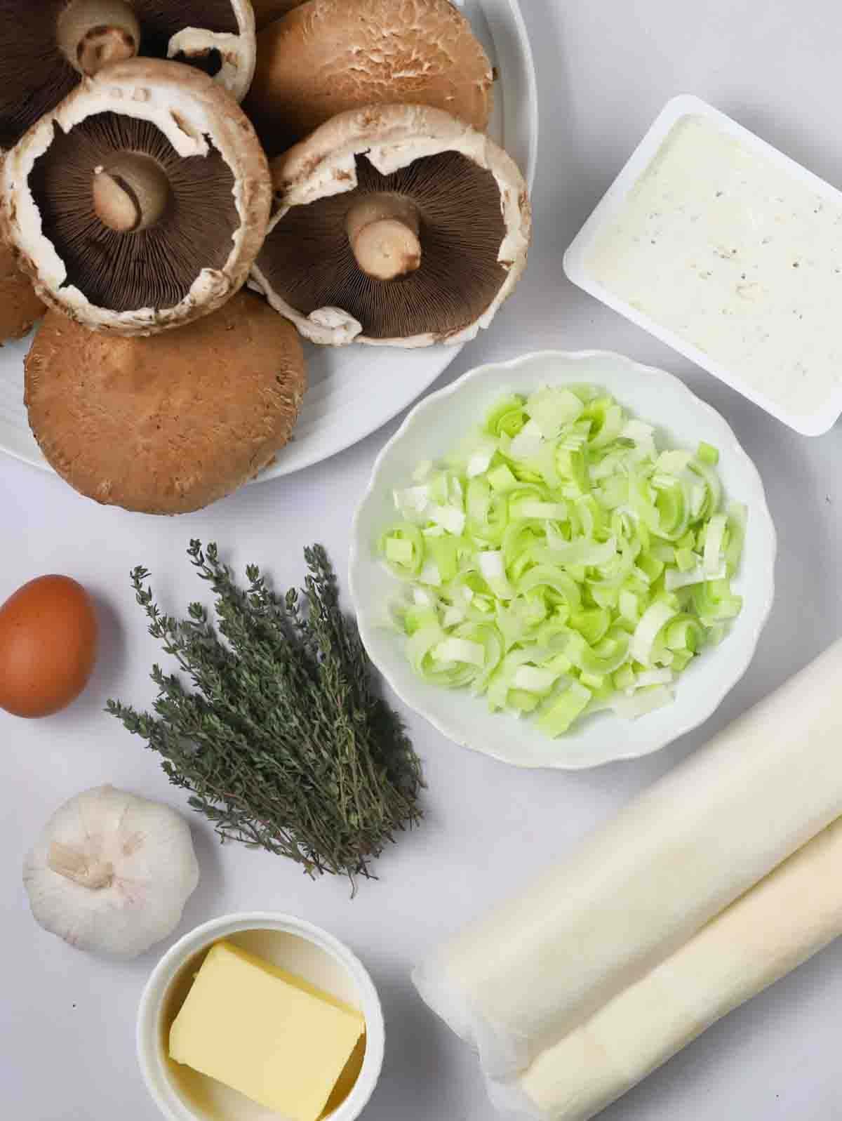 Ingredients for a mushroom wellington recipe laid out on a white table counter.
