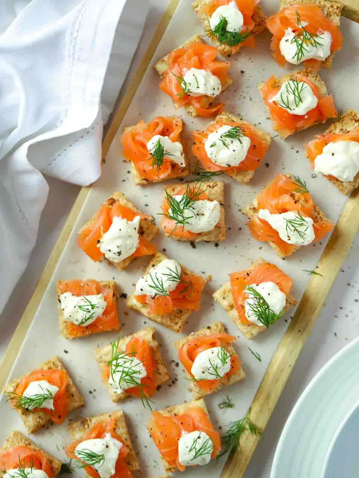 Perfect party food on a serving board. Smoked Salmon Canapés topped with creme fraiche and dill.