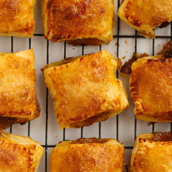 Nine golden baked puff pastry mince pies, cooling on a wire rack, straight out of the oven.