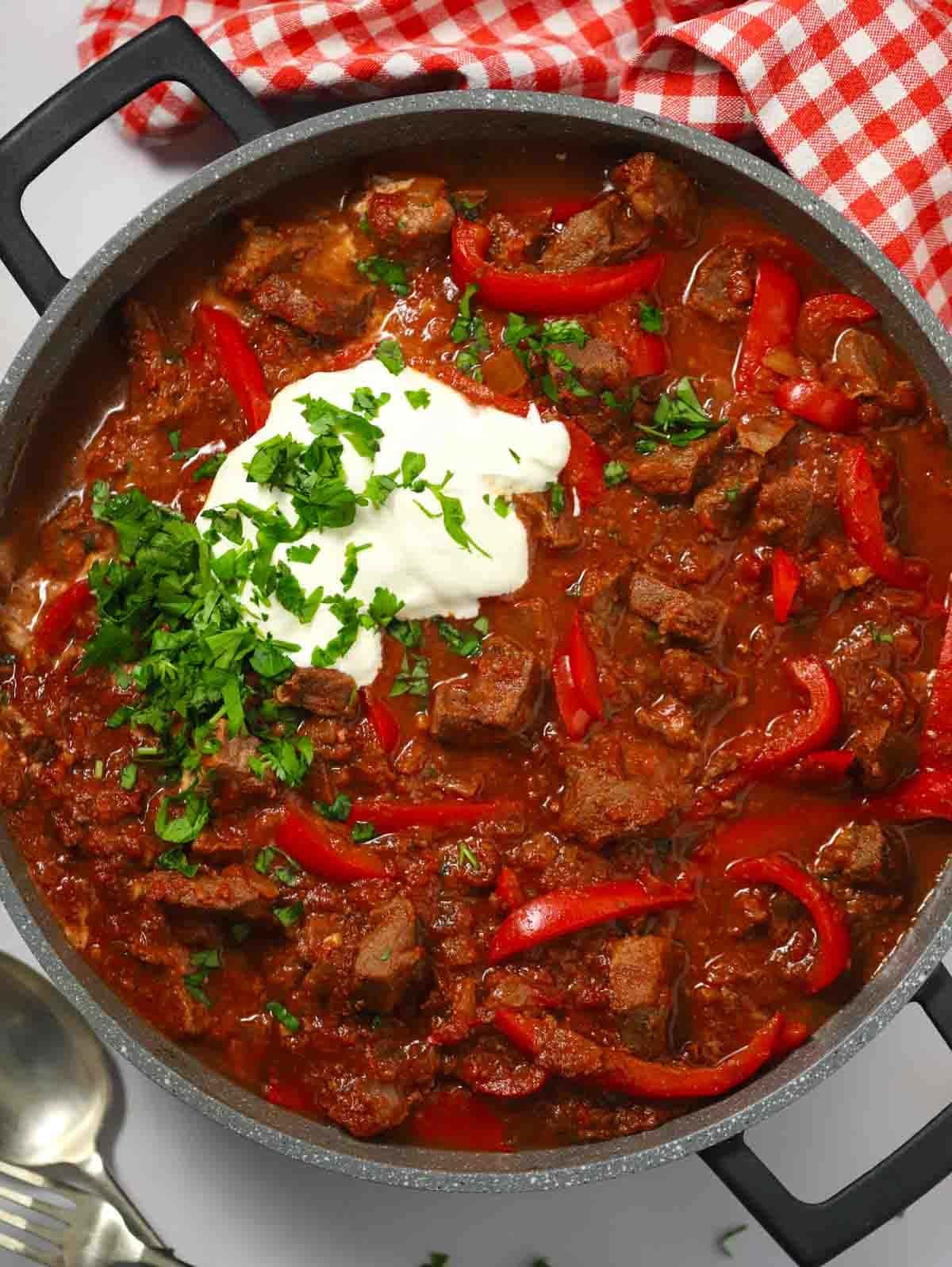 A big pan filled with slow cooker beef goulash, ready to serve.