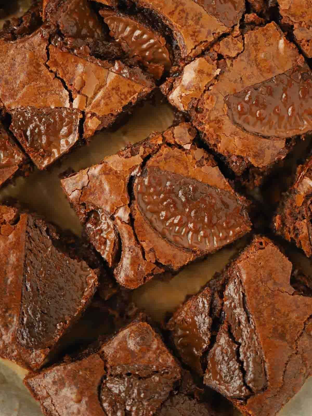 A close up of chocolate orange brownies on a board.