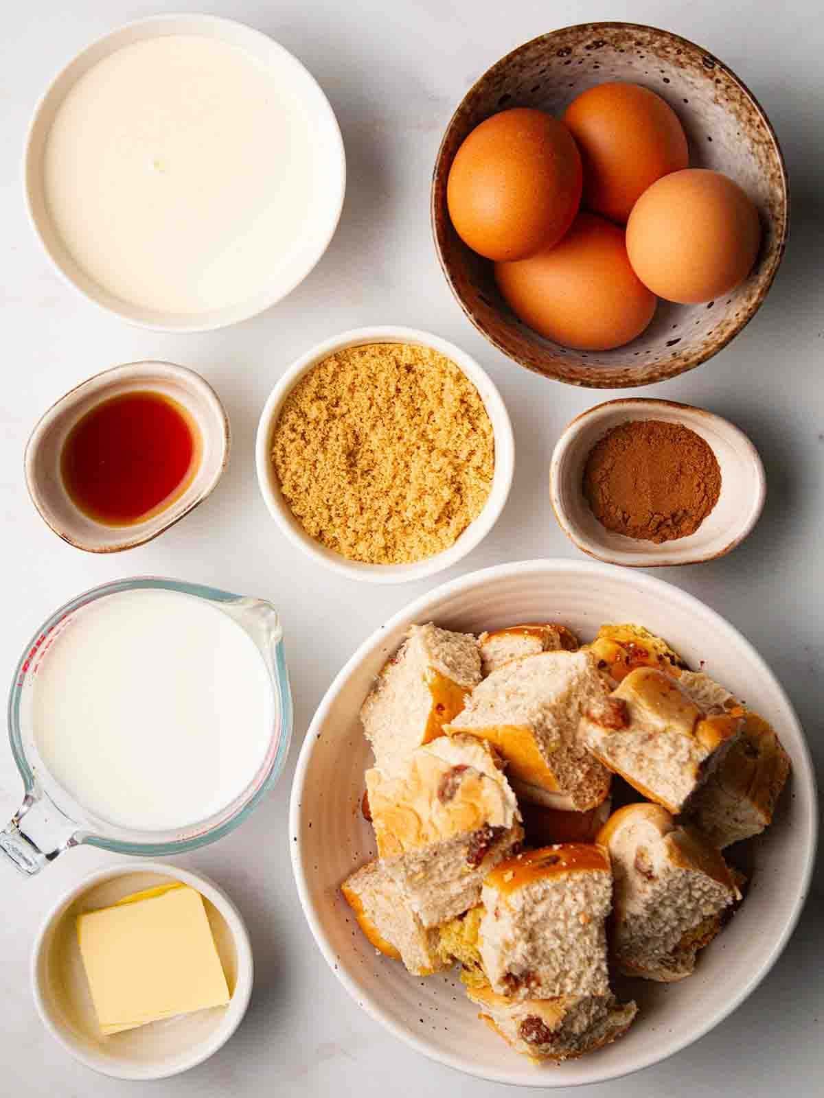 Ingredients for Hot Cross Bun Bread and Butter Pudding laid out on a counter.