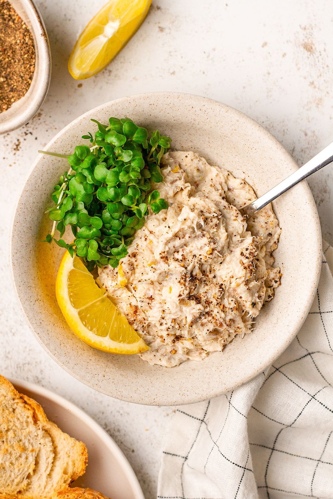 Lunch of mackerel pate is served on a white table.