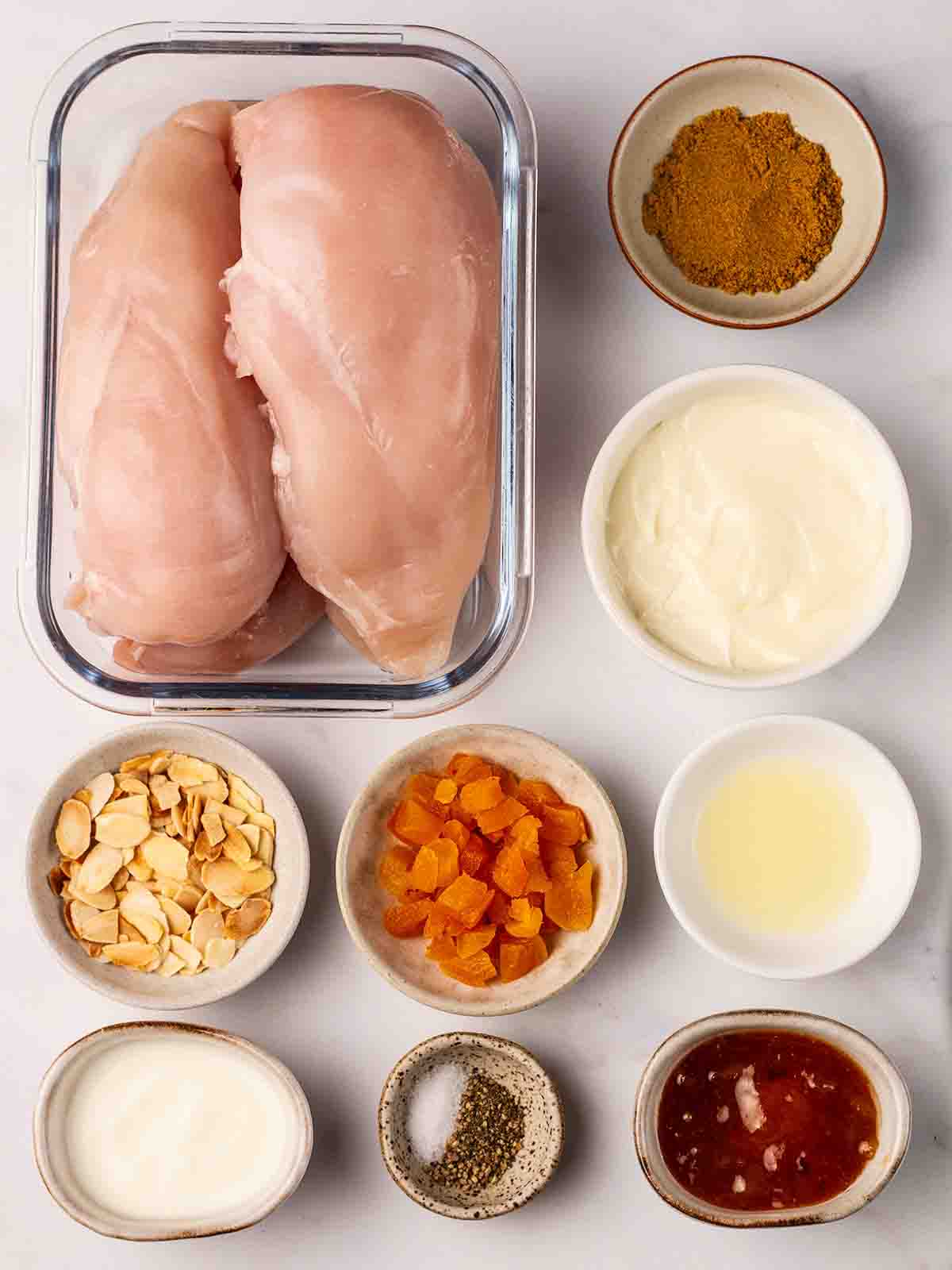 The raw ingredients for Coronation Chicken recipe laid out on a counter top.