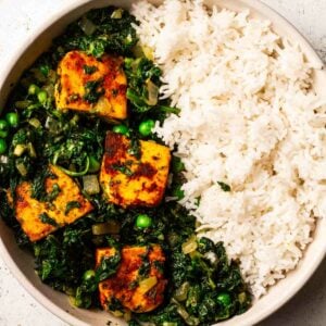 A close view of a bowl of palak paneer curry and rice.
