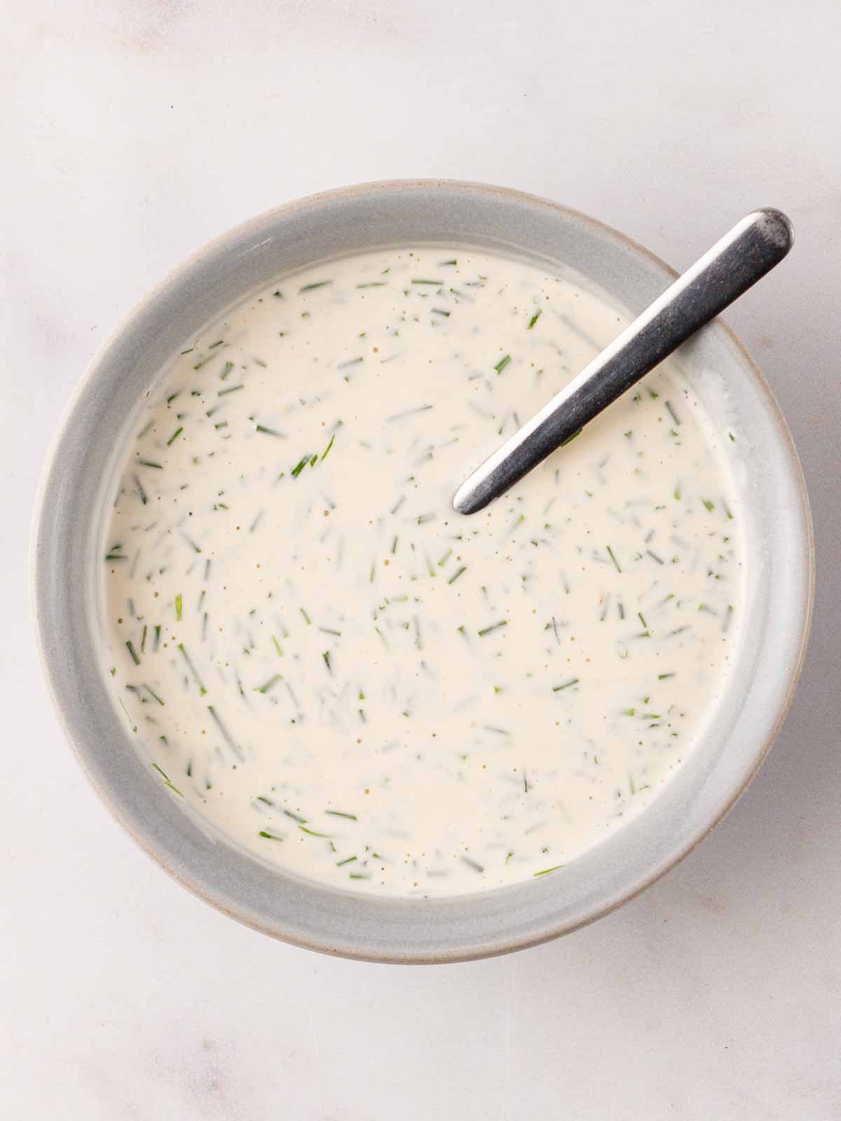 White dressing in a bowl for step 2 in the recipe for Tuna Pasta Salad.