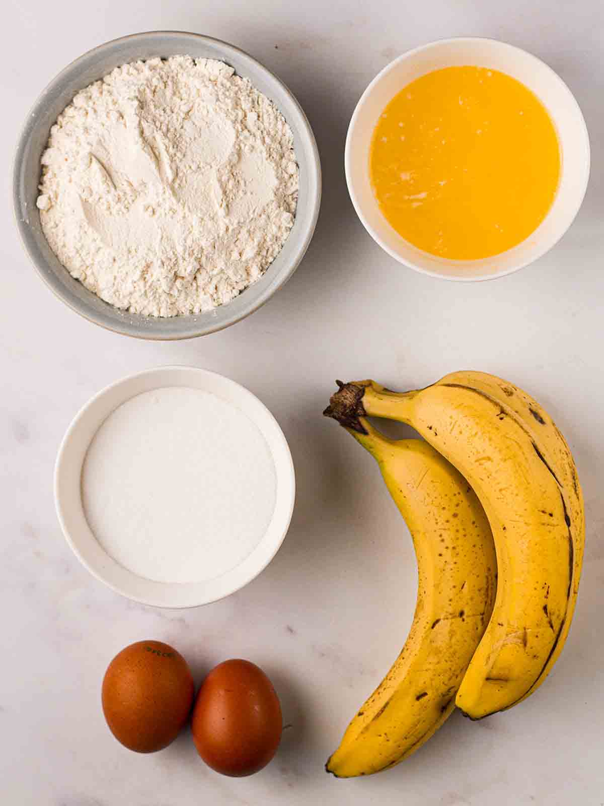 The ingredients for making a Banana Cake laid out on a counter top.