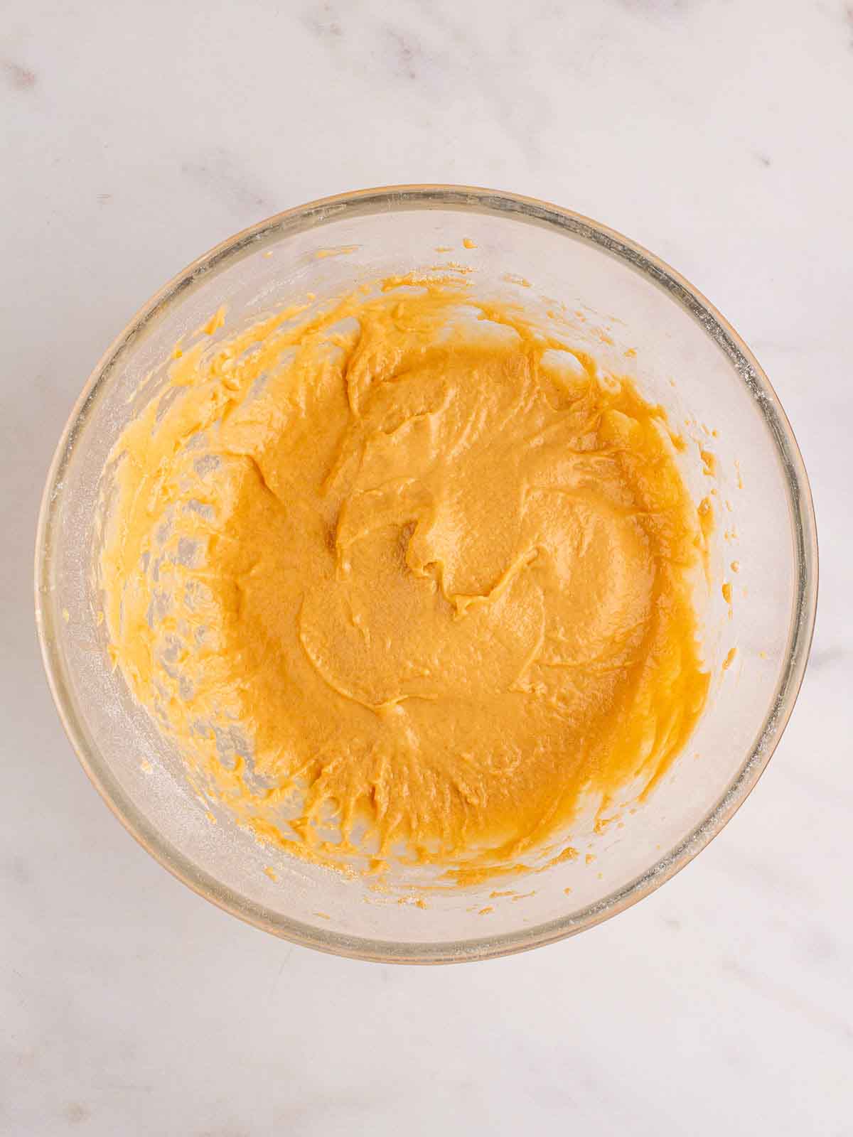 A glass bowl filled with yellow batter for a Yorkshire Pudding recipe. Step 1.