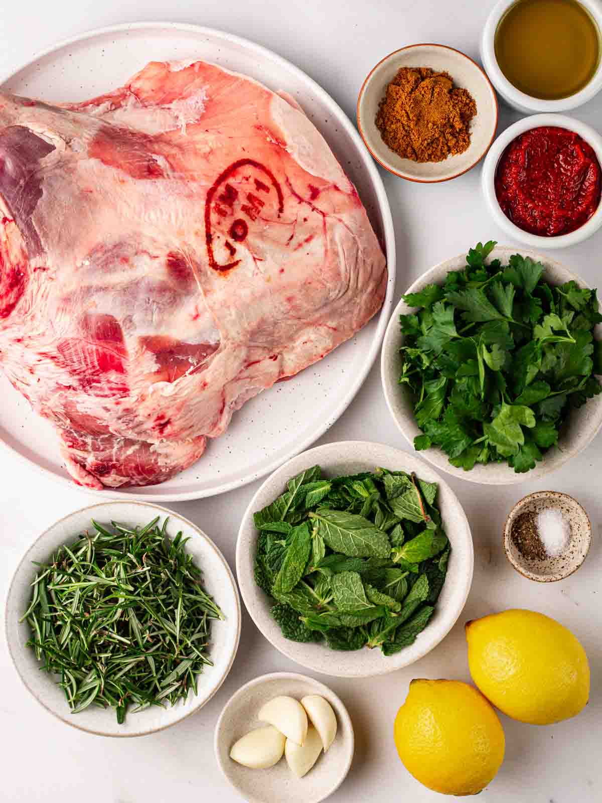 The raw ingredients for making a slow roast shoulder of lamb on a table.