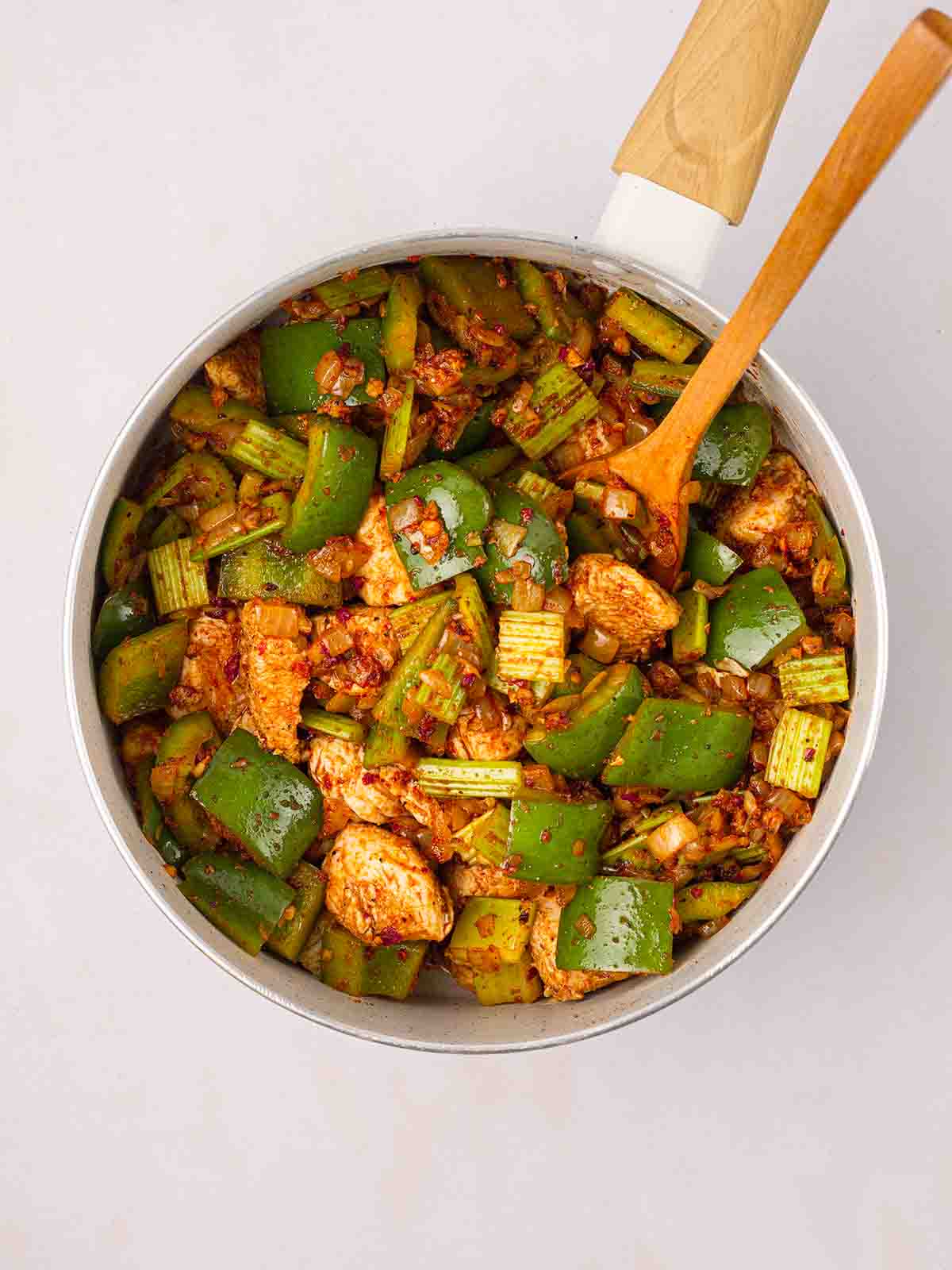 Green peppers and chicken cooking in a pan for step 2 in the recipe for Cajun Chicken Pasta.