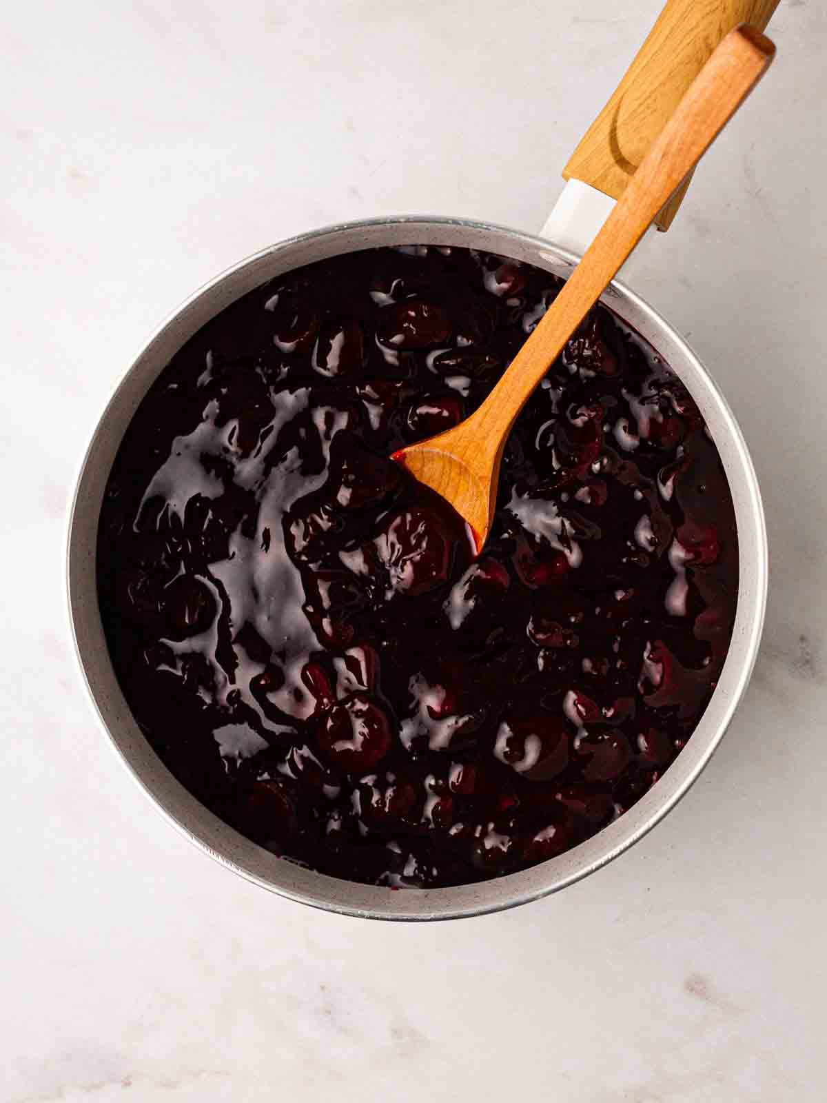 A pan filled with thick cherry filling for the recipe for Cherry Pie.