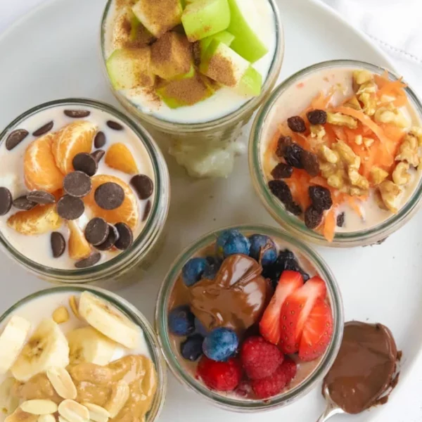 Looking down from above onto four jars of overnight oats with different toppings.