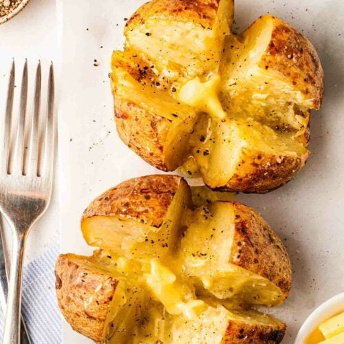 Air fryer jacket potatoes topped with butter.