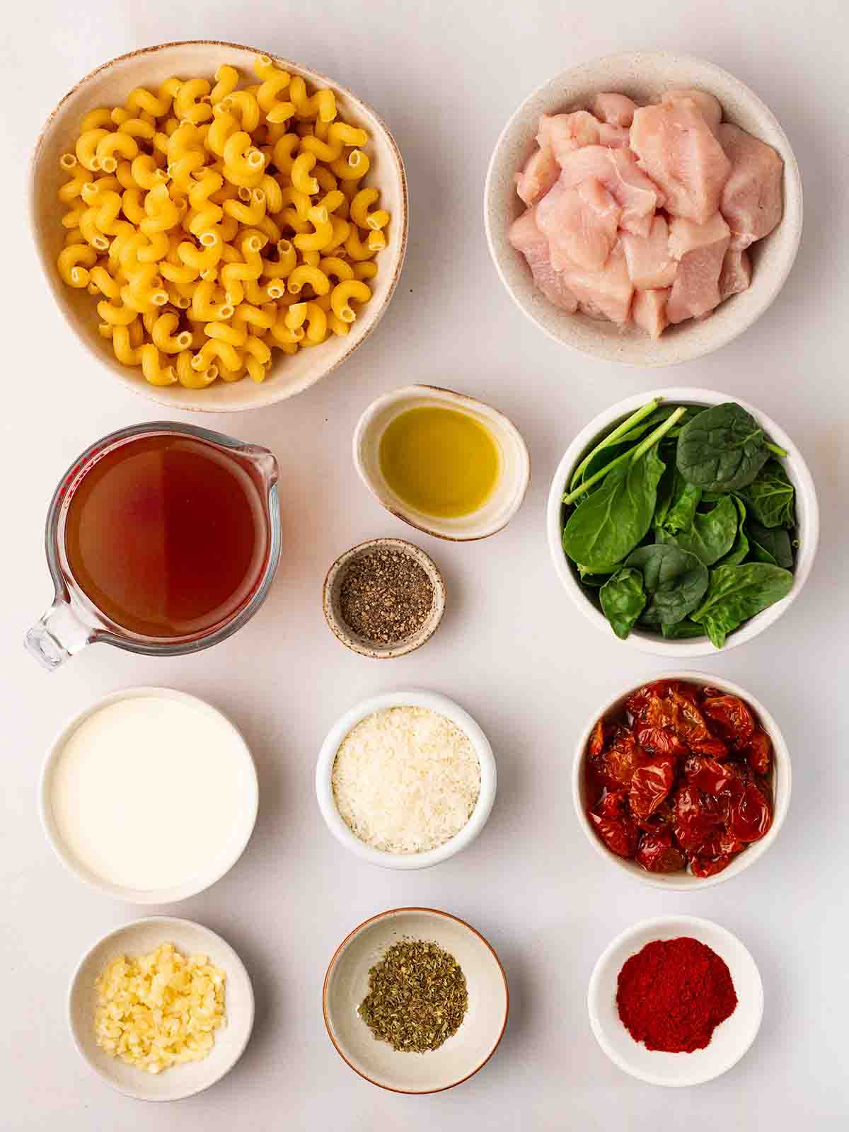 Ingredients for Marry Me Chicken Pasta ingredients in small bowls, laid out on a counter top.