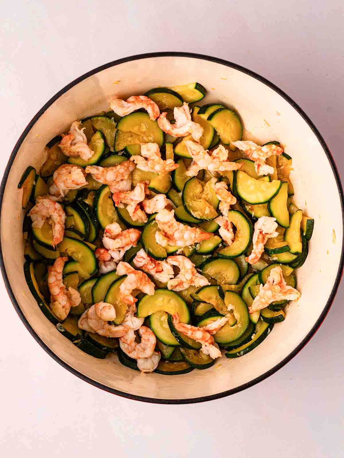 Courgettes and prawns in a pan cooking, for the recipe Prawn Pasta.