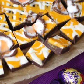 Squares of Creme Egg Fudge on a baking tin, ready to eat.
