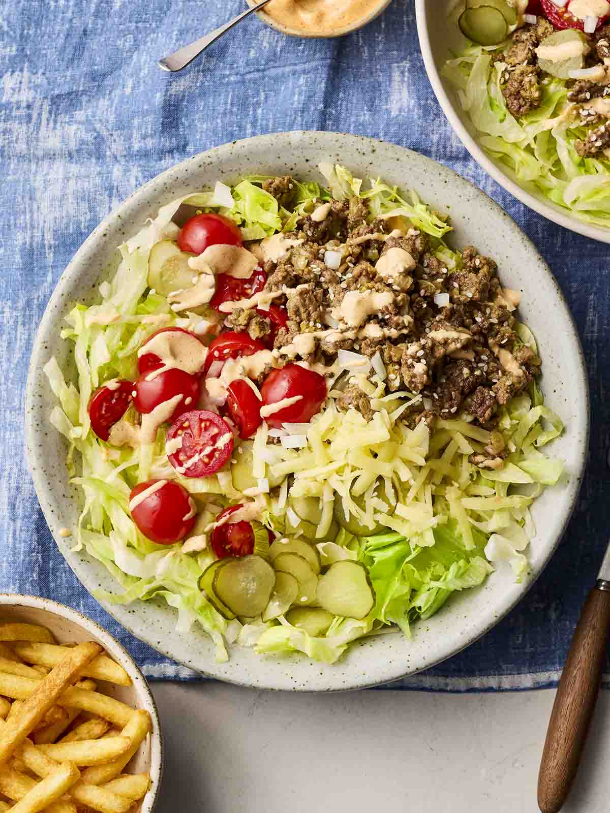 A plate filled with Big Mac Bowls ingredients, with chips on the side.