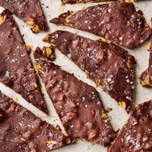 A close up of date bark with chocolate and peanut butter, with salt over the top, broken into pieces.
