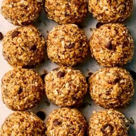 A close up of rows of energy balls with chocolate chips and oats.