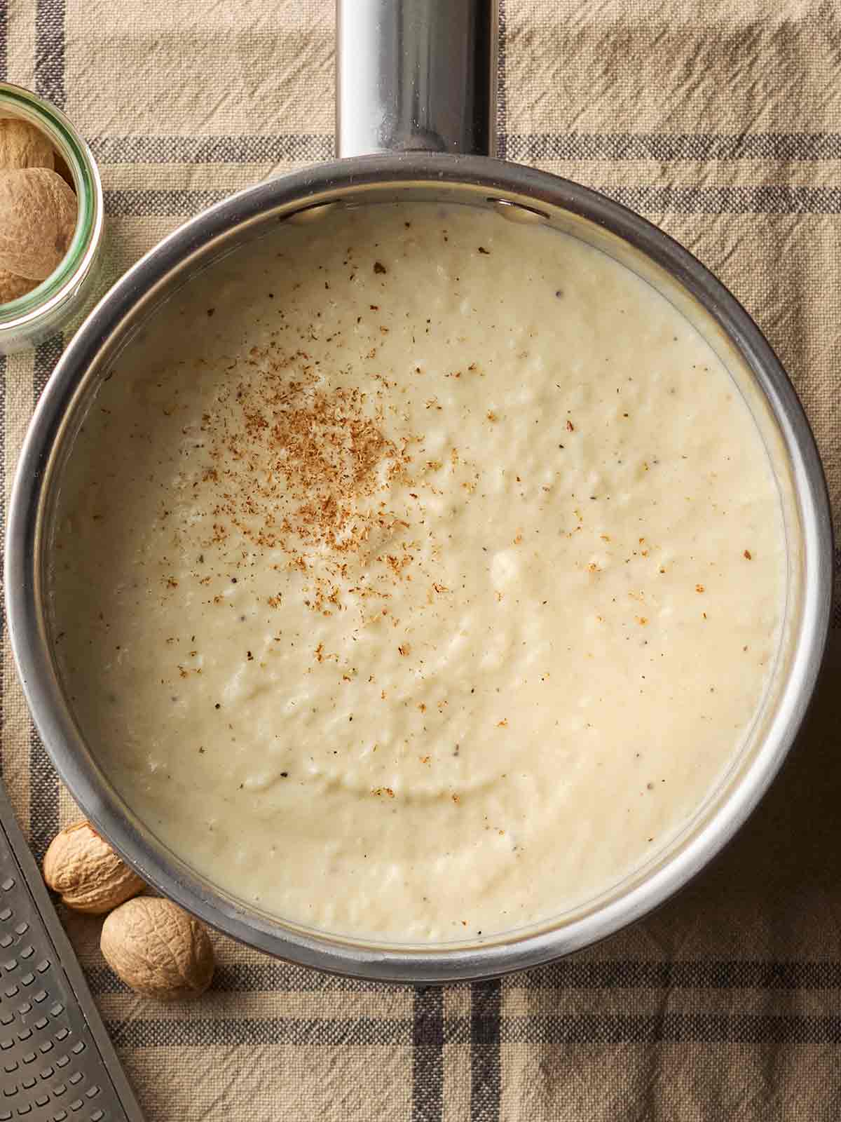 A pan with homemade bread sauce in on a table cloth.