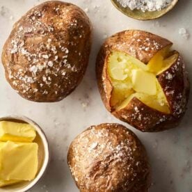 Jacket potatoes on a surface, ready to eat.