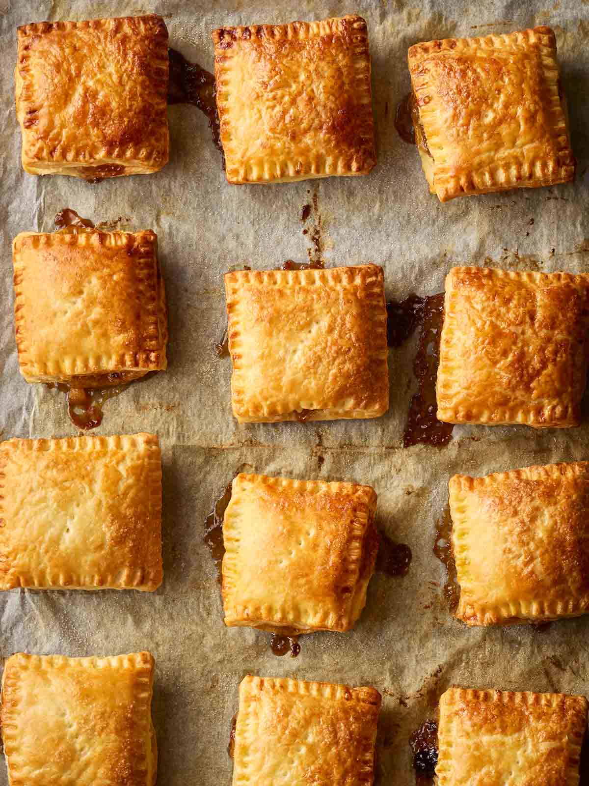 A batch of just-baked Mince Pies on a lined oven tray.