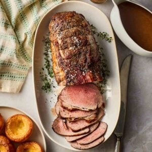 A platter of cooked roast been, sliced and ready to serve on a table for dinner.