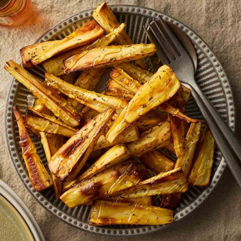 A bowl filled with golden roast parsnips, ready to serve.