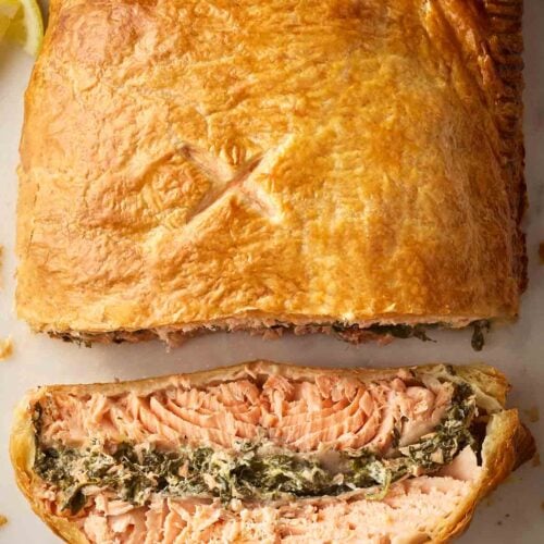 A Salmon Wellington - Salmon in pastry - ready to serve with a slice showing its filling.