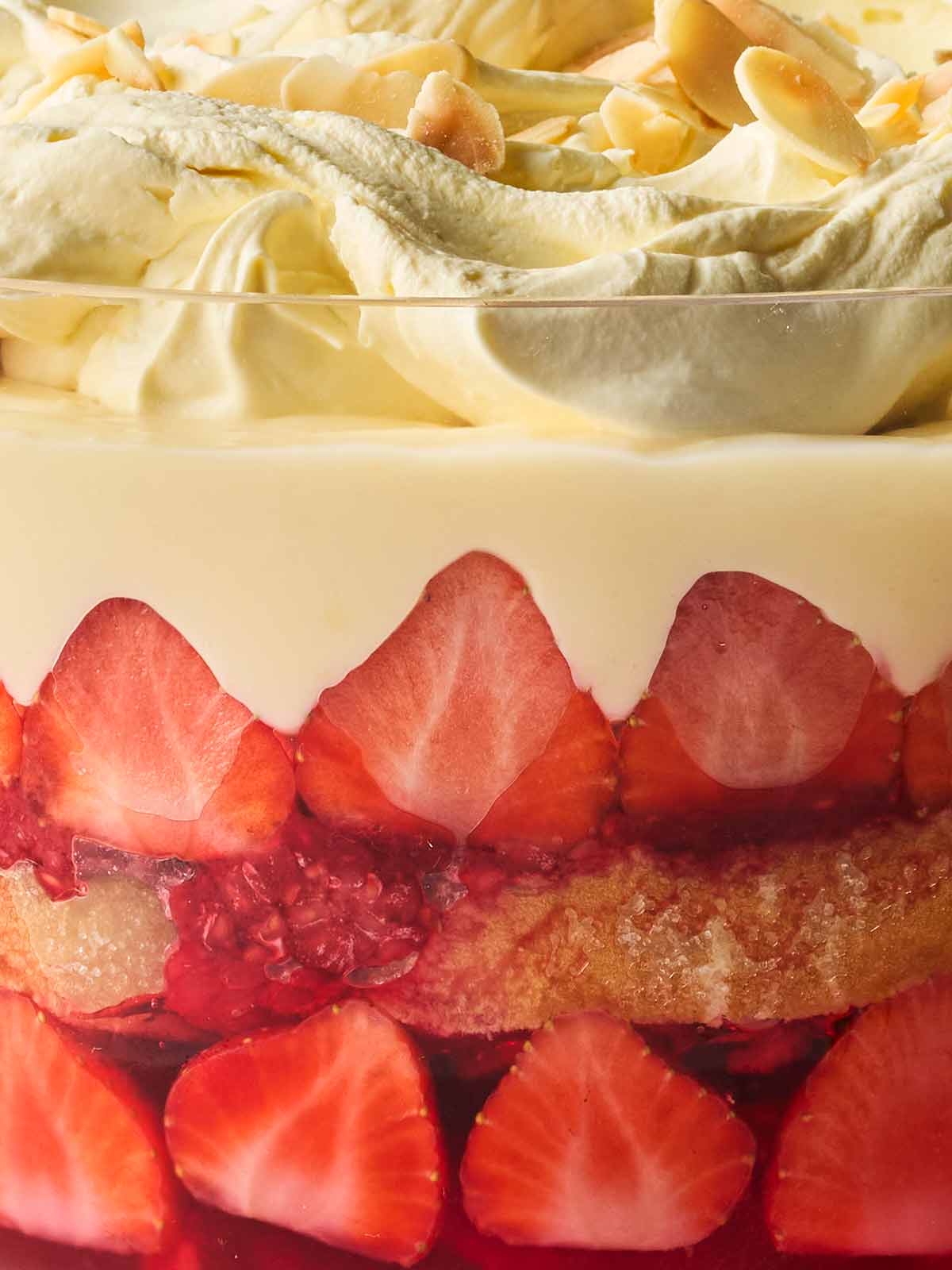 A close of up trifle layers, with fruit, custard and cream.