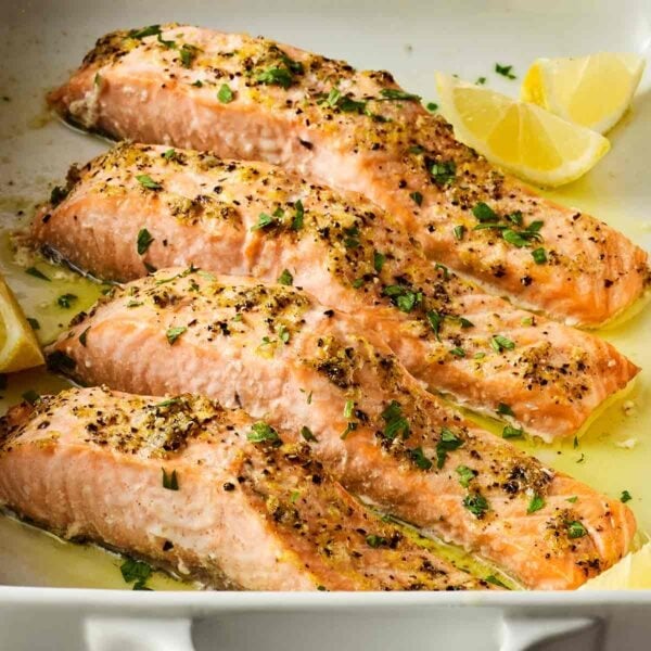 A close up of four pieces of salmon, cooked and ready to eat.