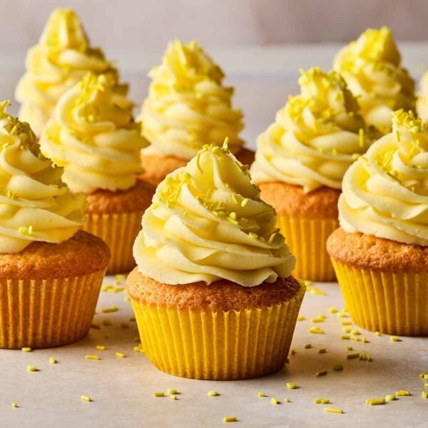 Lemon cupcakes from a side angle, with rows of finshed ones ready to eat.