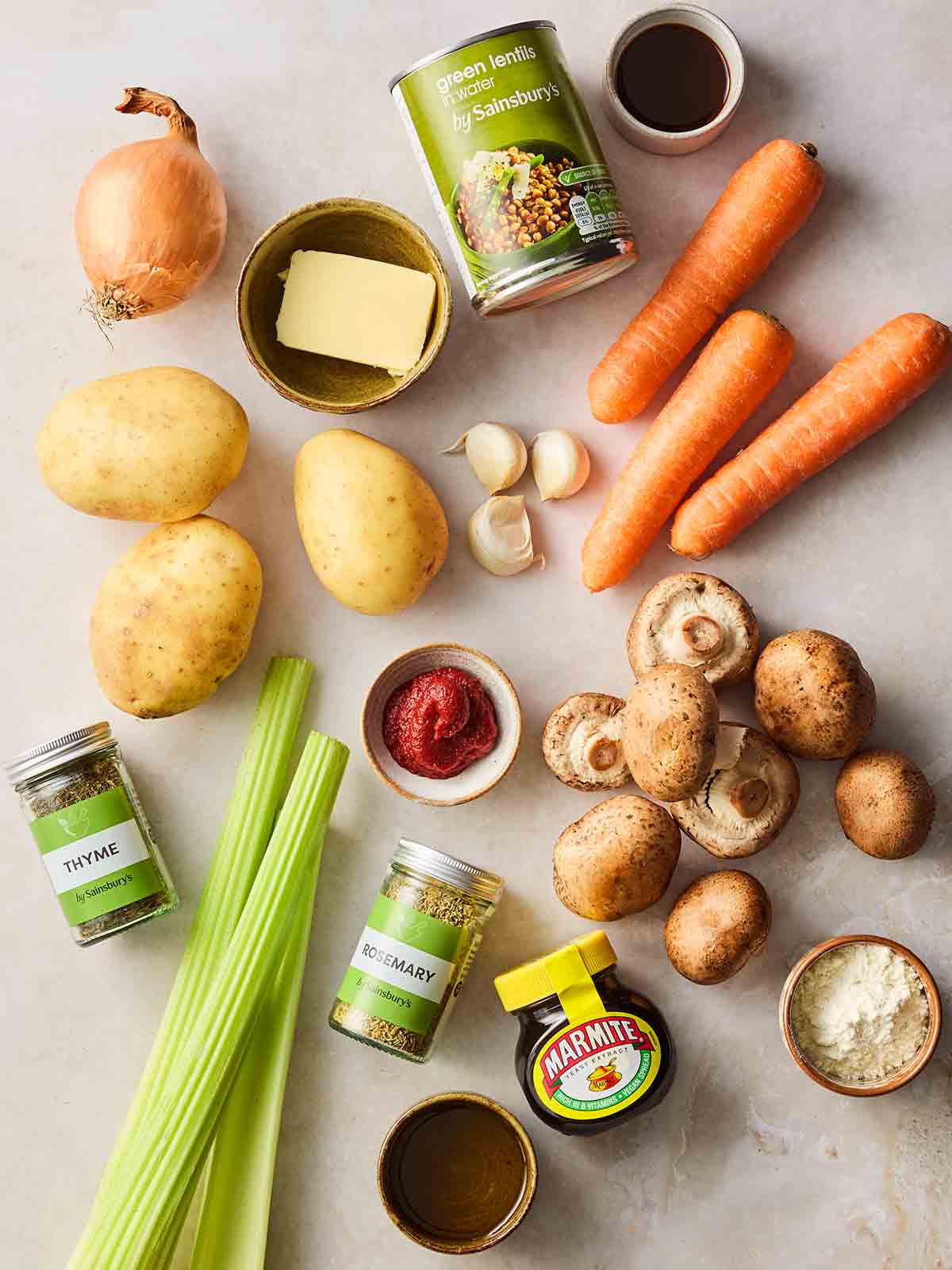 Ingredients laid out on a counter top, including tins and vegetables.