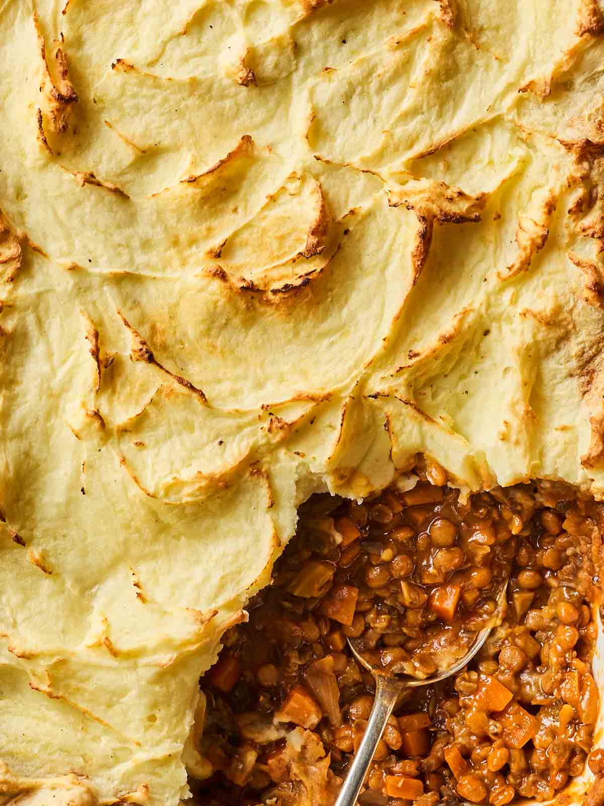 A close up of Vegetarian Cottage Pie cooked dish being served up for dinner.