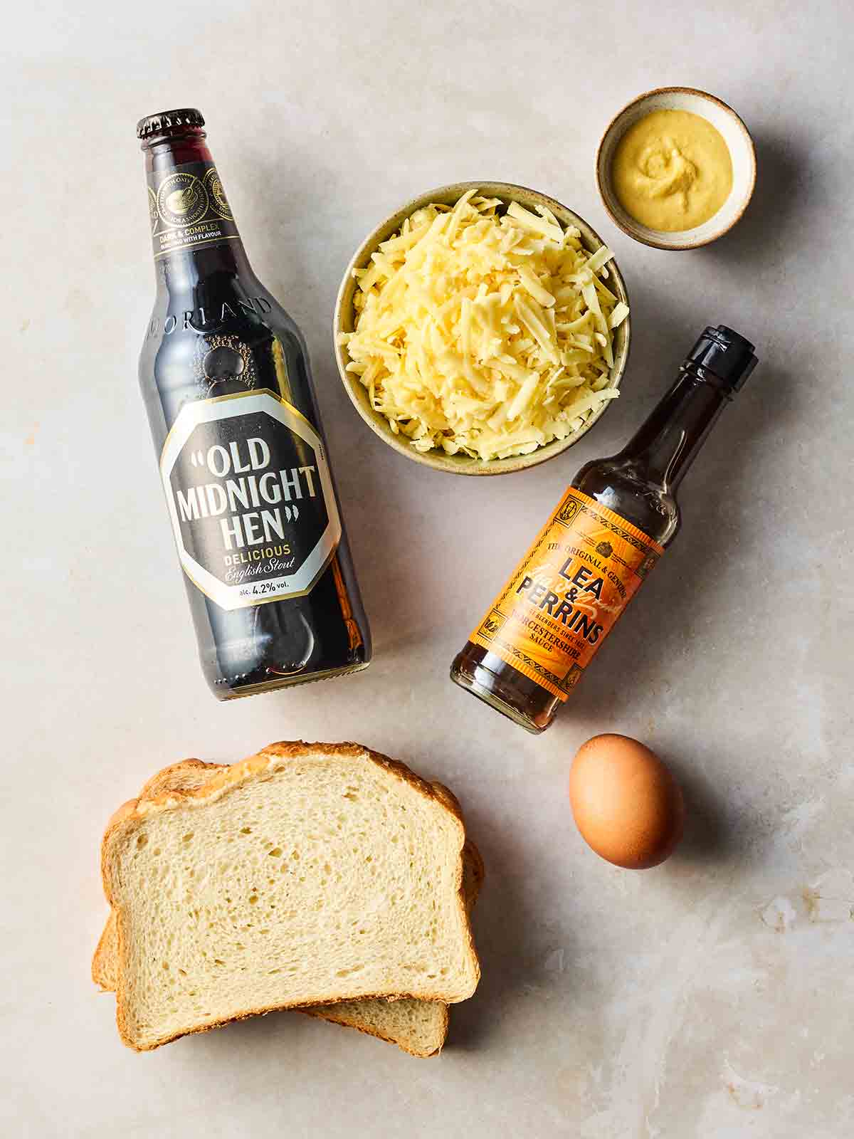 The ingredients for making Welsh rarebit laid out on a white surface.