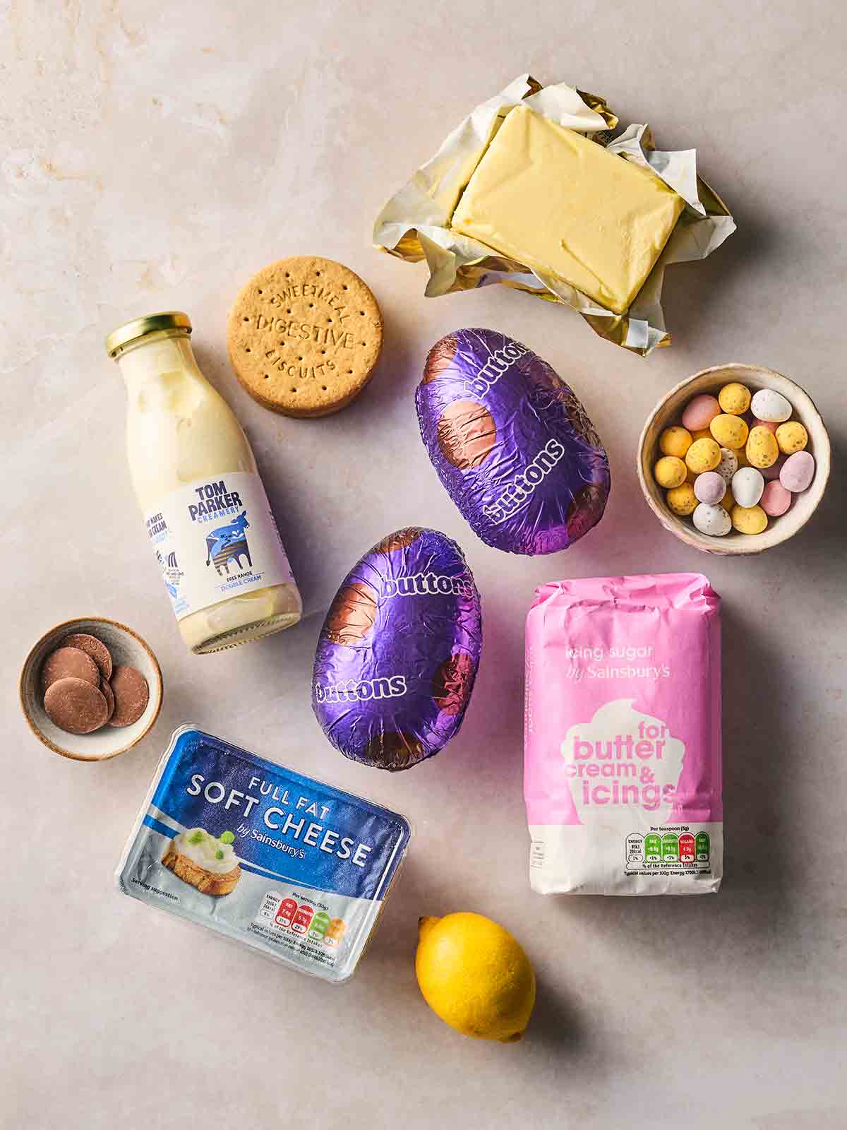 The ingredients for making Easter Egg Cheesecakes laid out on a white surface.