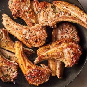 A pile of perfectly cooked Lamb Chops in a pan, ready to serve.