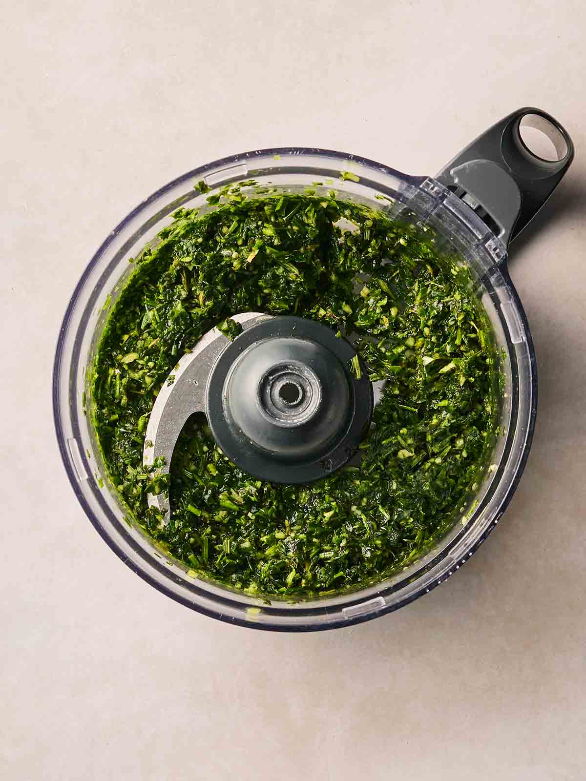 A green herby rub in a food processor.
