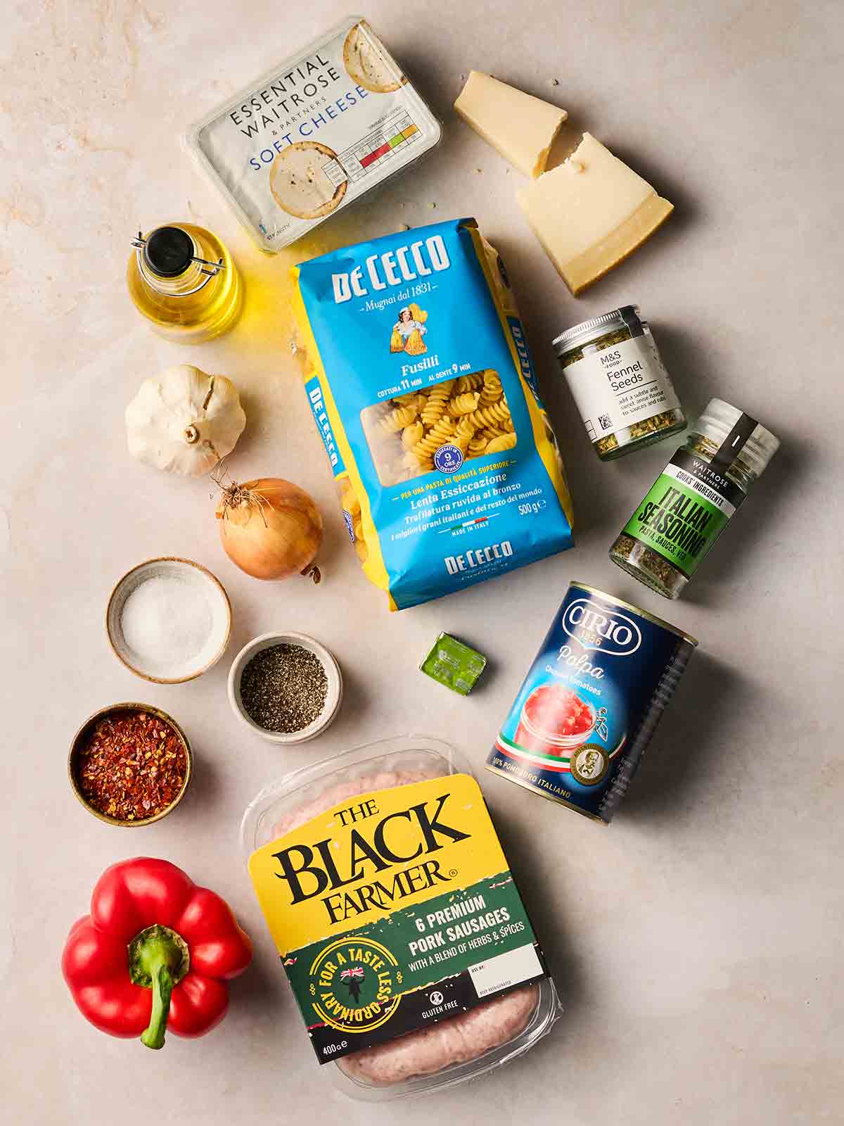 The ingredients for making Sausage Pasta laid out on a white counter.