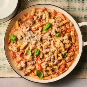 A close up of a pan of Sausage pasta, ready to serve at the table.