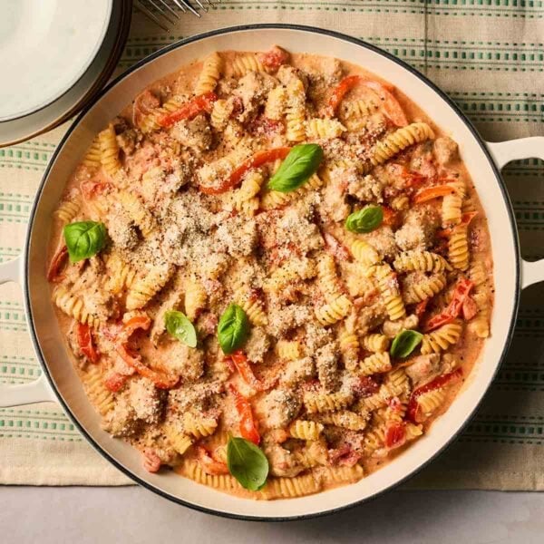 A close up of a pan of Sausage pasta, ready to serve at the table.