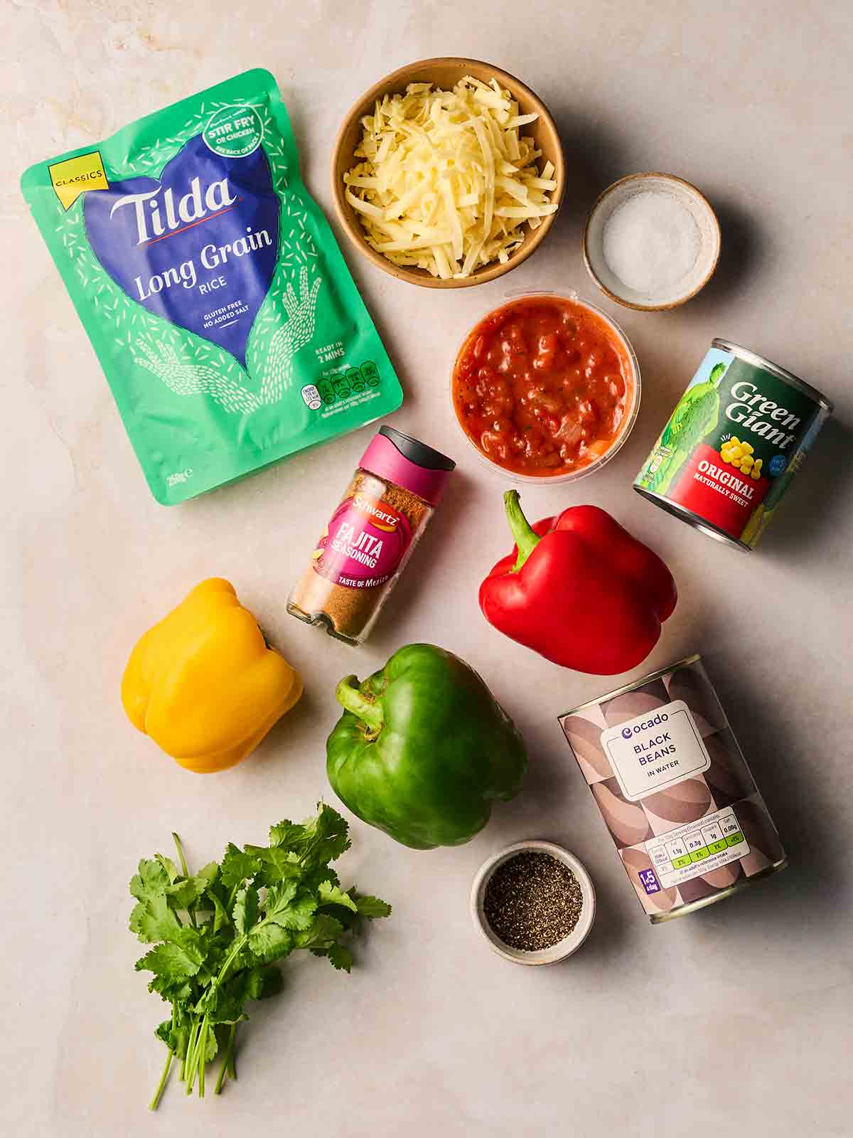 The ingredients for making Stuffed Peppers laid out on a white surface.