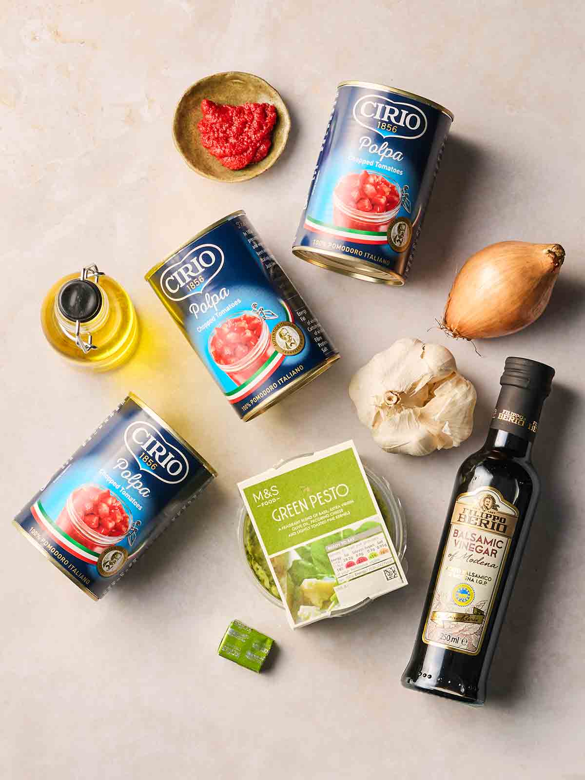 The ingredients for making simple Tomato Soup laid out on a white surface.