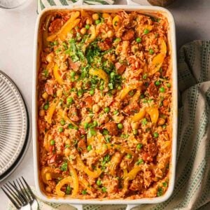 An oven dish with a one pan chorizo rice, a new dump and bake recipe from Taming Twins, on a table.