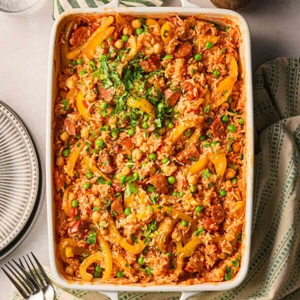 An oven dish with a one pan chorizo rice, a new dump and bake recipe from Taming Twins, on a table.